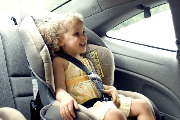 niña con cinturón de seguridad en el auto